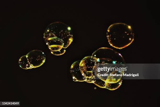 soap bubbles gold color at night - blowing bubbles stock pictures, royalty-free photos & images