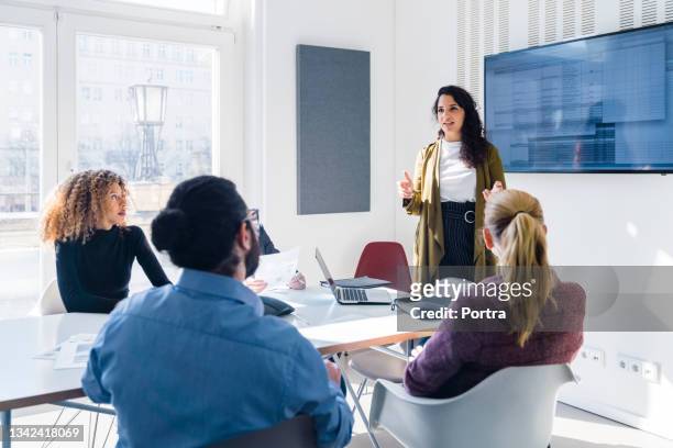 mujer de negocios dirigiéndose a sus colegas en una reunión de negocios corporativa - presentaci�ón fotografías e imágenes de stock