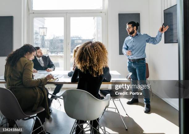 businessman presenting new project to team in boardroom - male presenter stock pictures, royalty-free photos & images