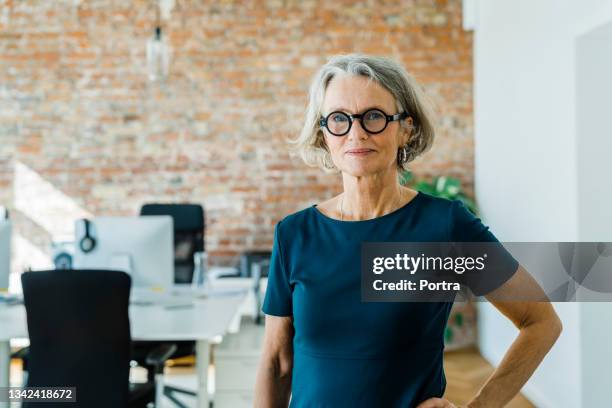 portrait of a senior businesswoman standing in office - mulher madura imagens e fotografias de stock