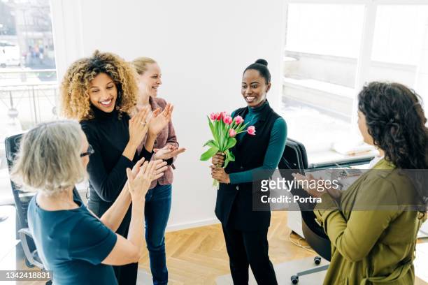 businesspeople applauding a colleague in office - receiving flowers stock pictures, royalty-free photos & images