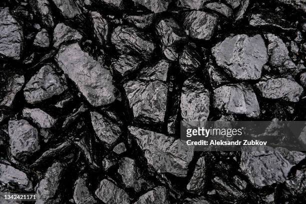 gray or black gravel or crushed stone for road construction and reconstruction, poured with bitumen. preparation and laying of asphalt. textured background. construction industry. - coal fotografías e imágenes de stock