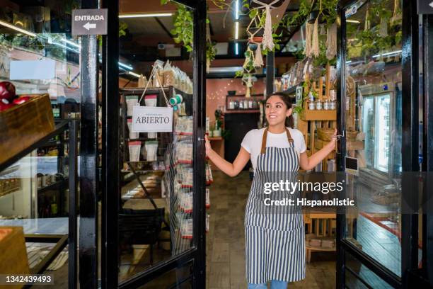 mujer feliz abriendo la puerta de un supermercado - opening event fotografías e imágenes de stock