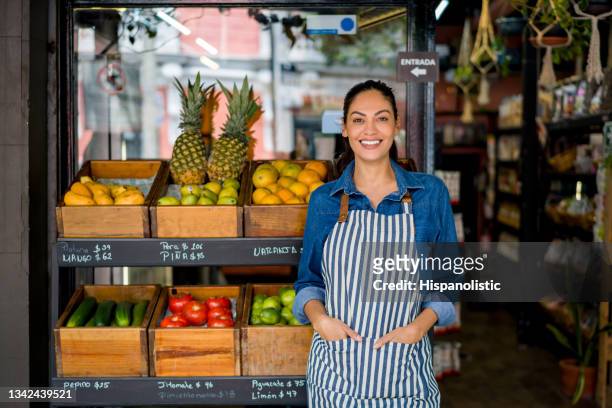 glückliche verkäuferin, die auf einem lokalen lebensmittelmarkt arbeitet - entrepreneurship stock-fotos und bilder