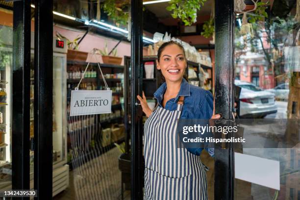 mujer abriendo su pequeño negocio - conceptos de supermercado local - apertura fotografías e imágenes de stock