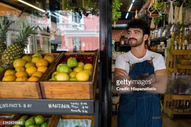 man working at a local supermarket and waiting for clients - feirante imagens e fotografias de stock