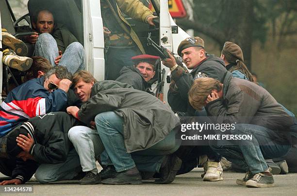 Bosnian special forces soldier returns fire 06 April 1992 downtown Sarajevo as he and civilians come under fire from Serbian snipers. The Serb...