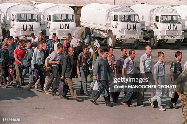 Some 51 Bosnian POW's walk 21 August 1992 pas UN trucks inside the UN headquaters in Sarajevo after being exchanged for 50 Serbian prisoners of war.