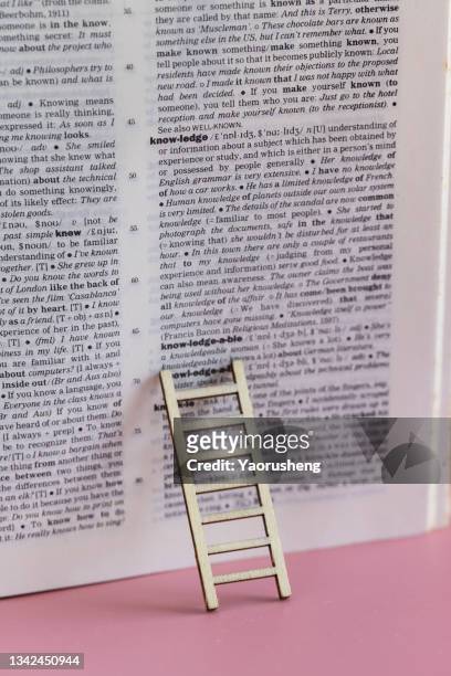 concept photo: ladder up for learning new knowledge with english dictionary - help engels woord stockfoto's en -beelden