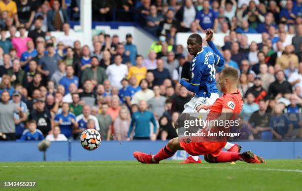 Abdoulaye Doucoure of Everton scores their side's second goal whilst under pressure from Ben Gibson of Norwich City during the Premier League match...