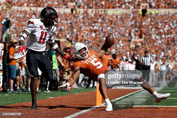 Bijan Robinson of the Texas Longhorns scores a receiving touchdown while defended by Eric Monroe of the Texas Tech Red Raiders in the first quarter...