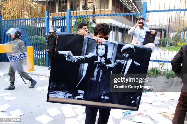 Man holds a poster featuring American actors John Travolta and Samuel L. Jackson in a scene from the film 'Pulp Fiction' following a break in at the...