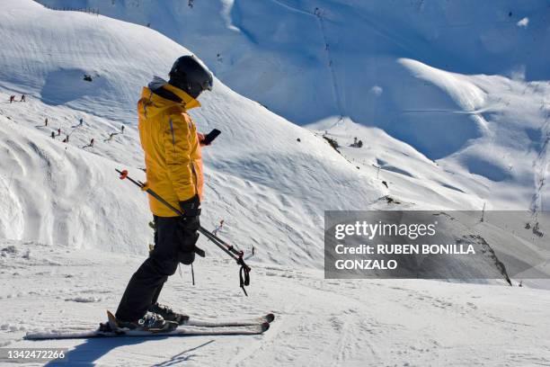 skier using smart phone on top snow mountain practising ski sport - extreme skiing photos et images de collection