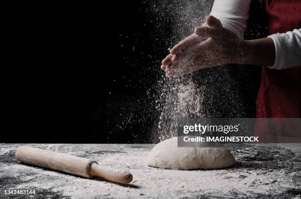 man spreading flour on bread dough - knåda bildbanksfoton och bilder