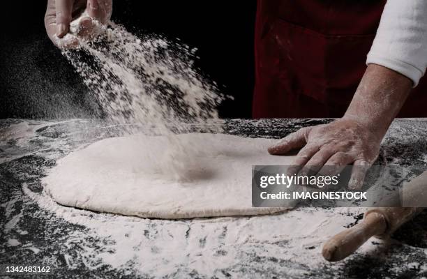 chef shaping the dough to make a pizza - farina foto e immagini stock