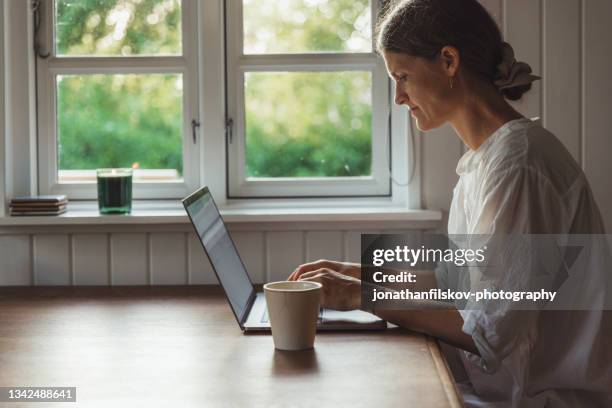 skandinavische frau online mit laptop - dänemark gemütlich stock-fotos und bilder