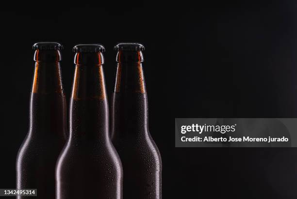 three beer bottles on black background. close up - beer bottle stock pictures, royalty-free photos & images