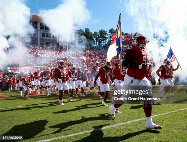 Grant Gibson of the North Carolina State Wolfpack leads his team onto the field for a game against the Clemson Tigers at Carter-Finley Stadium on...