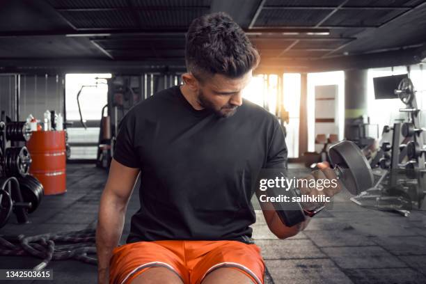 a man doing arm workout with dumbbell at gym - bizeps stock pictures, royalty-free photos & images