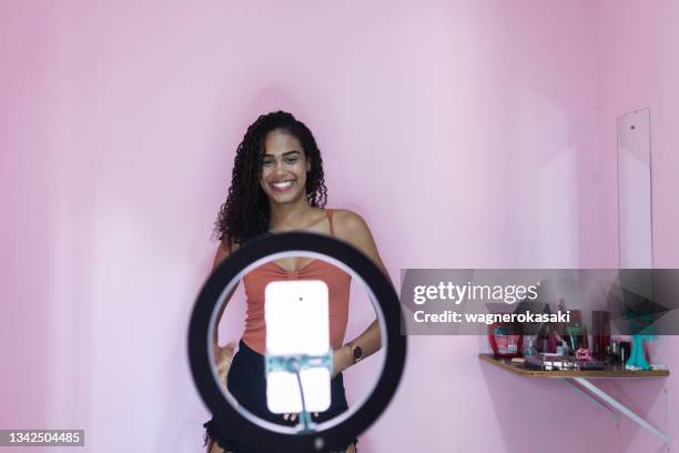 black young woman filming herself dancing at home to share on social media - beauty influencer stock pictures, royalty-free photos & images