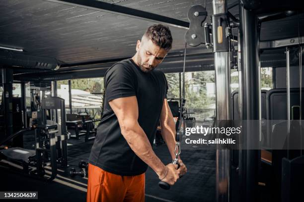 un hombre haciendo ejercicio de empuje de tríceps en el gimnasio - triceps extension fotografías e imágenes de stock