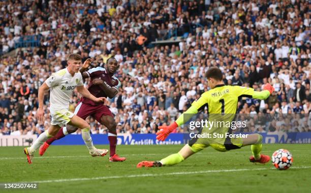 West Ham striker Michail Antonio shoots to score the winning goal past Leeds goalkeeper Illan Meslier as defender Charlie Cresswell looks on during...