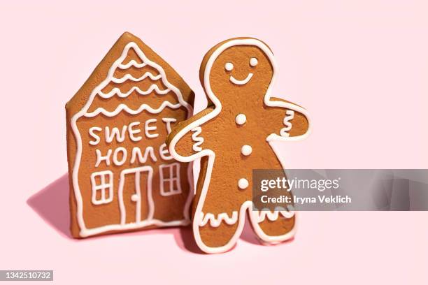 gingerbread man and house on pastel pink background. - gingerbread biscuit stock pictures, royalty-free photos & images