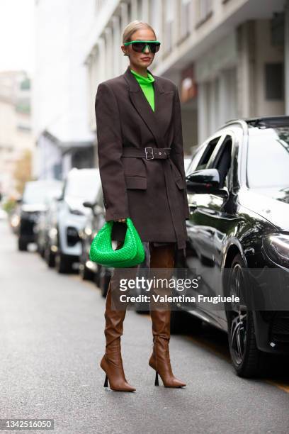 Leonie Hanne outside Philosophy fashion show wearing a green flou turtleneck, brown structured coat, green bag and camel leather thigh high boots...