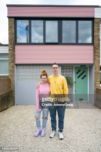 retrato al aire libre de una pareja caucásica frente a una casa moderna - casa de dos pisos fotografías e imágenes de stock