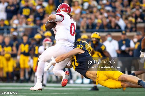 Defensive end Aidan Hutchinson of the Michigan Wolverines tackles quarterback Noah Vedral of the Rutgers Scarlet Knights in the third quarter at...