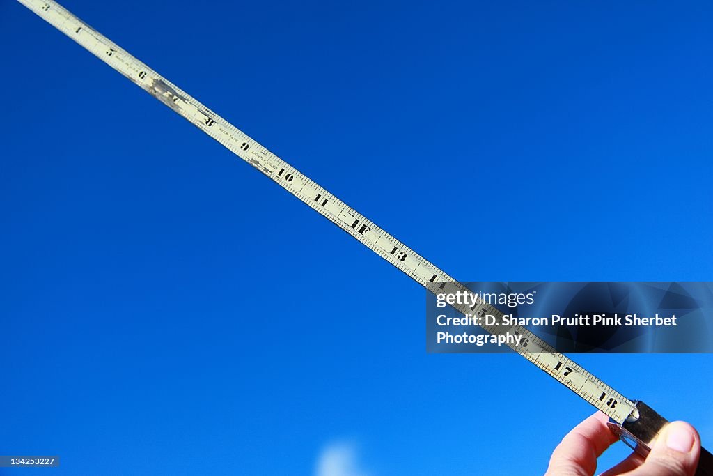 Measuring tape on blue sky