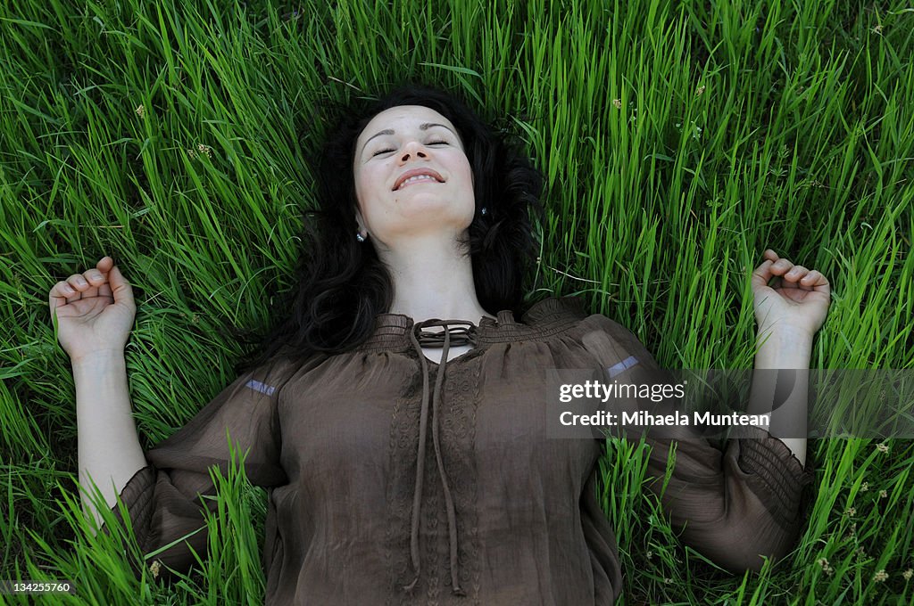 Happy woman lying in grass