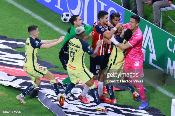 Jesus Molina and Raul Gudino of Chivas hold Henry Martin of America to avoid a confrontation while Miguel Ponce of Chivas puts a hand on Martin's...