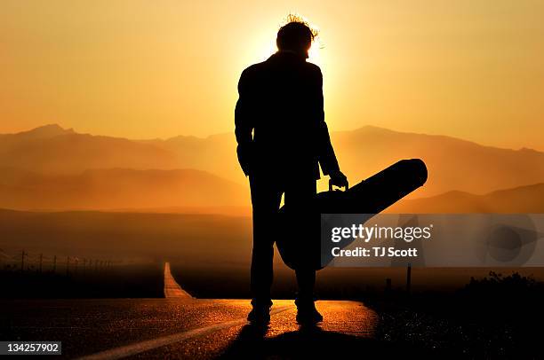 man stands in silhouette with his guitar - guitar case fotografías e imágenes de stock