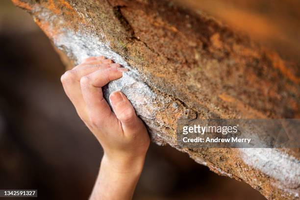 outdoor rock climber hand holding rock cliff edge, close up - gesso roccia foto e immagini stock