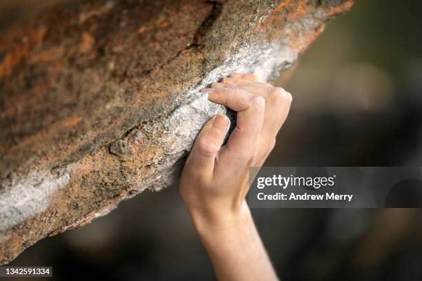outdoor rock climber hand holding rock cliff edge, close up - soloklettern stock-fotos und bilder