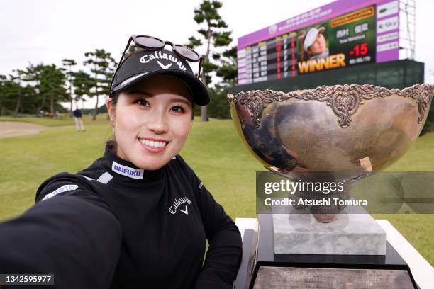 Yuna Nishimura of Japan imitates the selfie after winning the tournament following the final round of the Miyagi TV Cup Dunlop Ladies Open at Rifu...