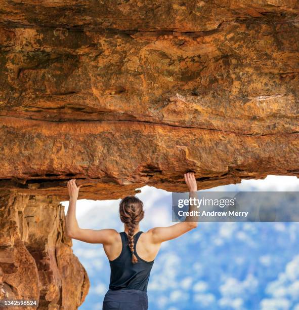 woman rock climber arms up holding cliff, under rocky overhang, mountain - titan stock pictures, royalty-free photos & images