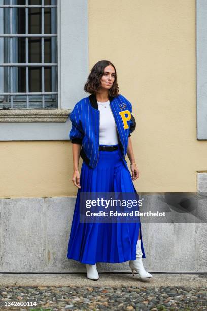 Erika Boldrin wears a royal blue electric with small yellow stripes sport bomber coat with a yellow embroidered P from Philosophy, a white ribbed...