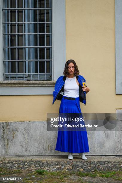 Erika Boldrin wears a royal blue electric with small yellow stripes sport bomber coat with a yellow embroidered P from Philosophy, a white ribbed...