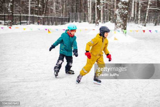 little brothers ice skating - family ice skate stock pictures, royalty-free photos & images