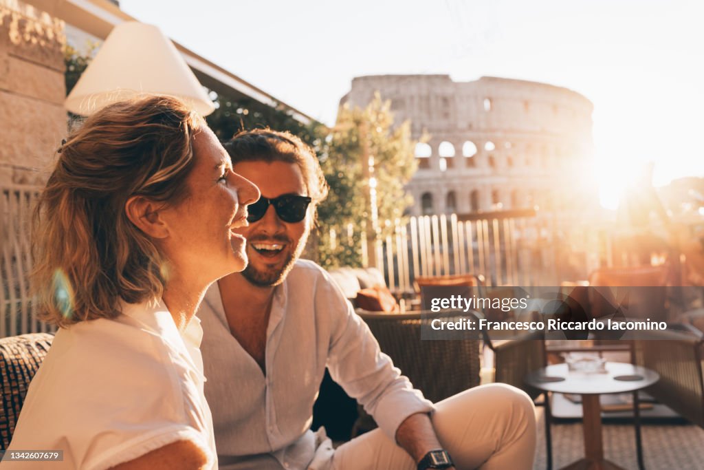 Romantic couple having fun at sunset in Rome, Italy. Colosseum and sunstar
