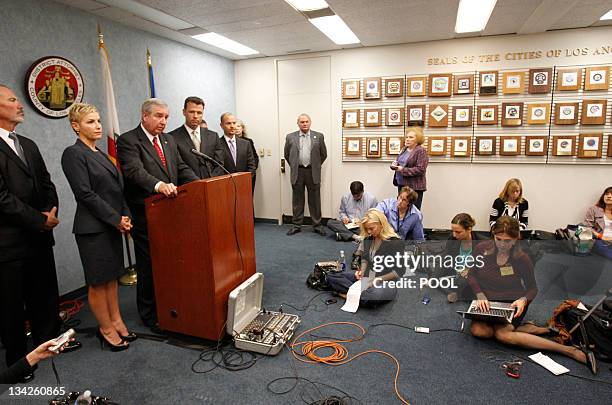 Reporters work on the floor as Los Angeles District Attorney Steve Cooley speaks to the media with the prosecution team surrounding him after Dr....