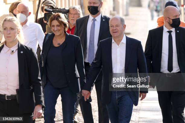 Olaf Scholz, chancellor candidate of the German Social Democrats , and his wife Britta Ernst arrive to cast their ballots in federal parliamentary...
