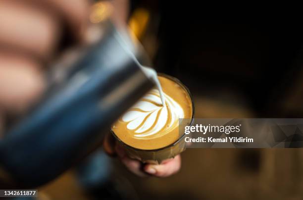 close up of hand pouring coffee latte art - coffee bildbanksfoton och bilder