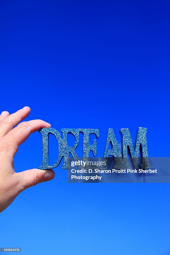 Human hand holding word"dream" in hand
