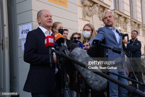 Olaf Scholz, chancellor candidate of the German Social Democrats , speaks briefly to the media as he departs after casting his ballot in federal...
