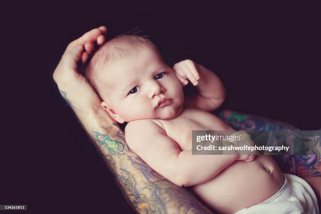 Baby resting in tattooed arms