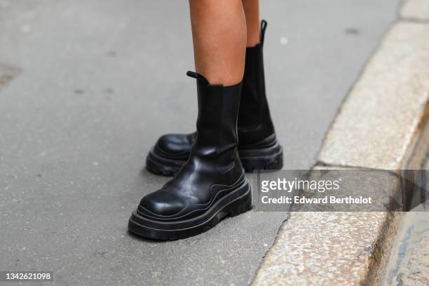 Aida Domenech wears black shiny leather ankle boots, outside the Ermanno Scervino fashion show during the Milan Fashion Week - Spring / Summer 2022...