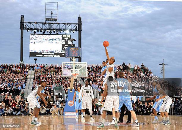 Adreian Payne of the Michigan State Spartans tips the ball from John Henson of the North Carolina Tar Heels to start the game during the Quicken...